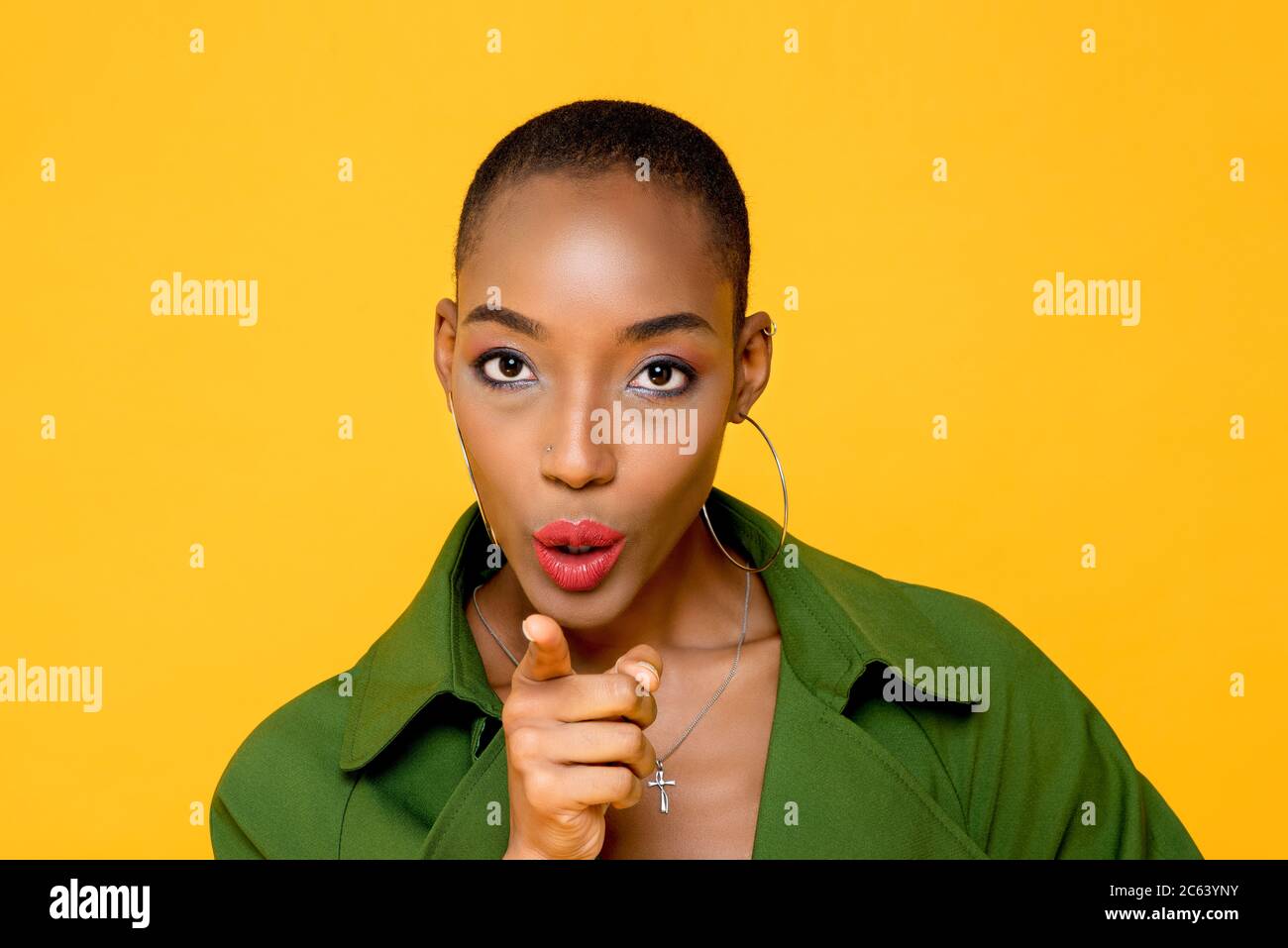 Powerful beautiful African American woman leader pointing finger at camara and saying You isolated on yellow background Stock Photo
