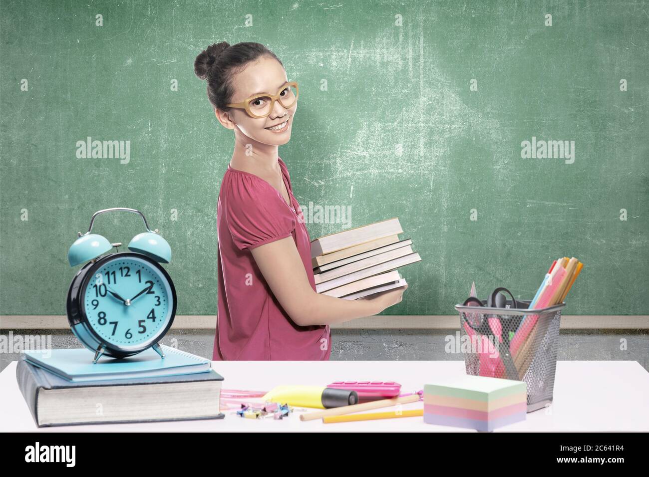 Asian student woman carrying a stack of books in the classroom. Back to ...