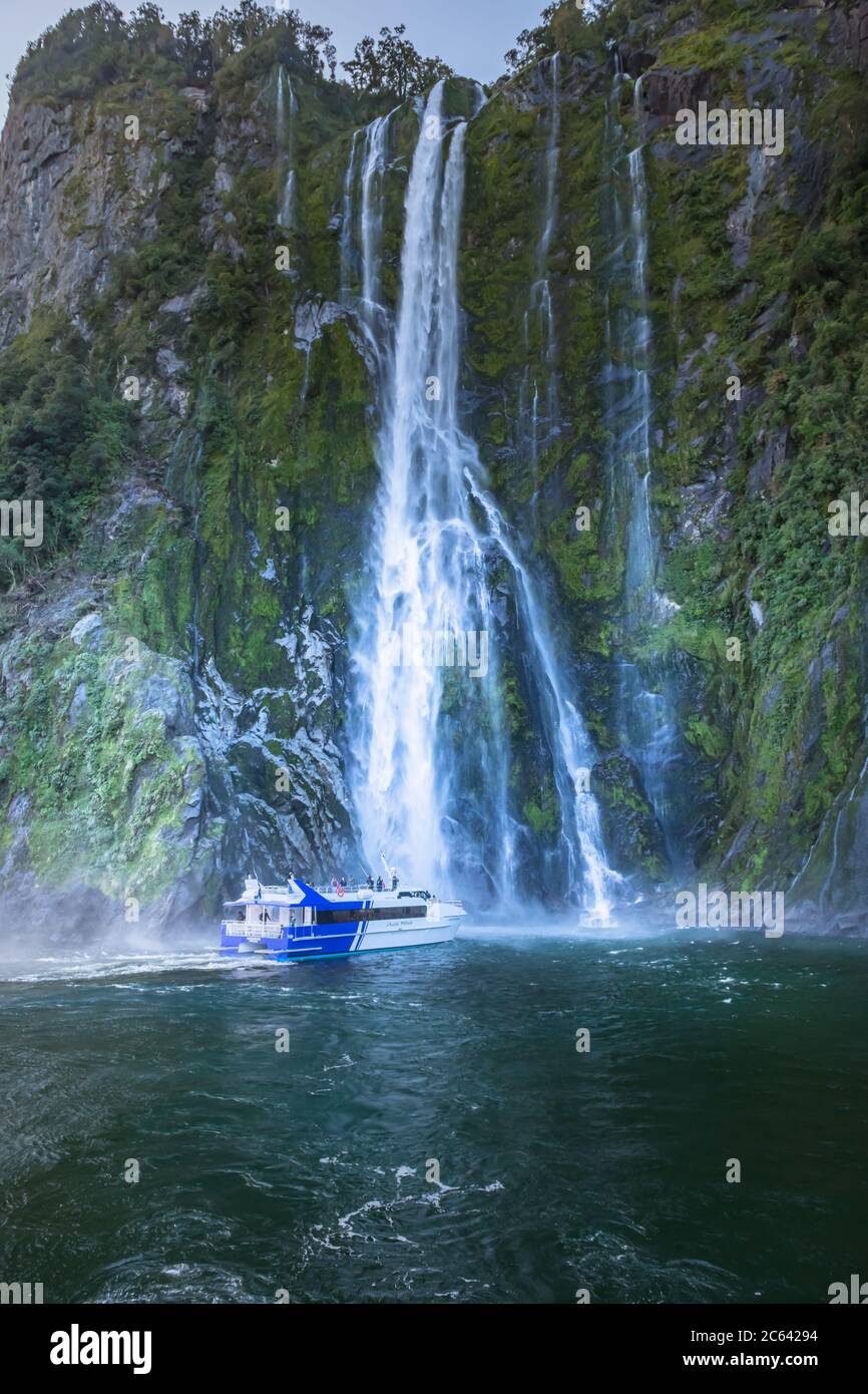 Tour boat under Stirling Falls, Milford Sound, New Zealand Stock Photo