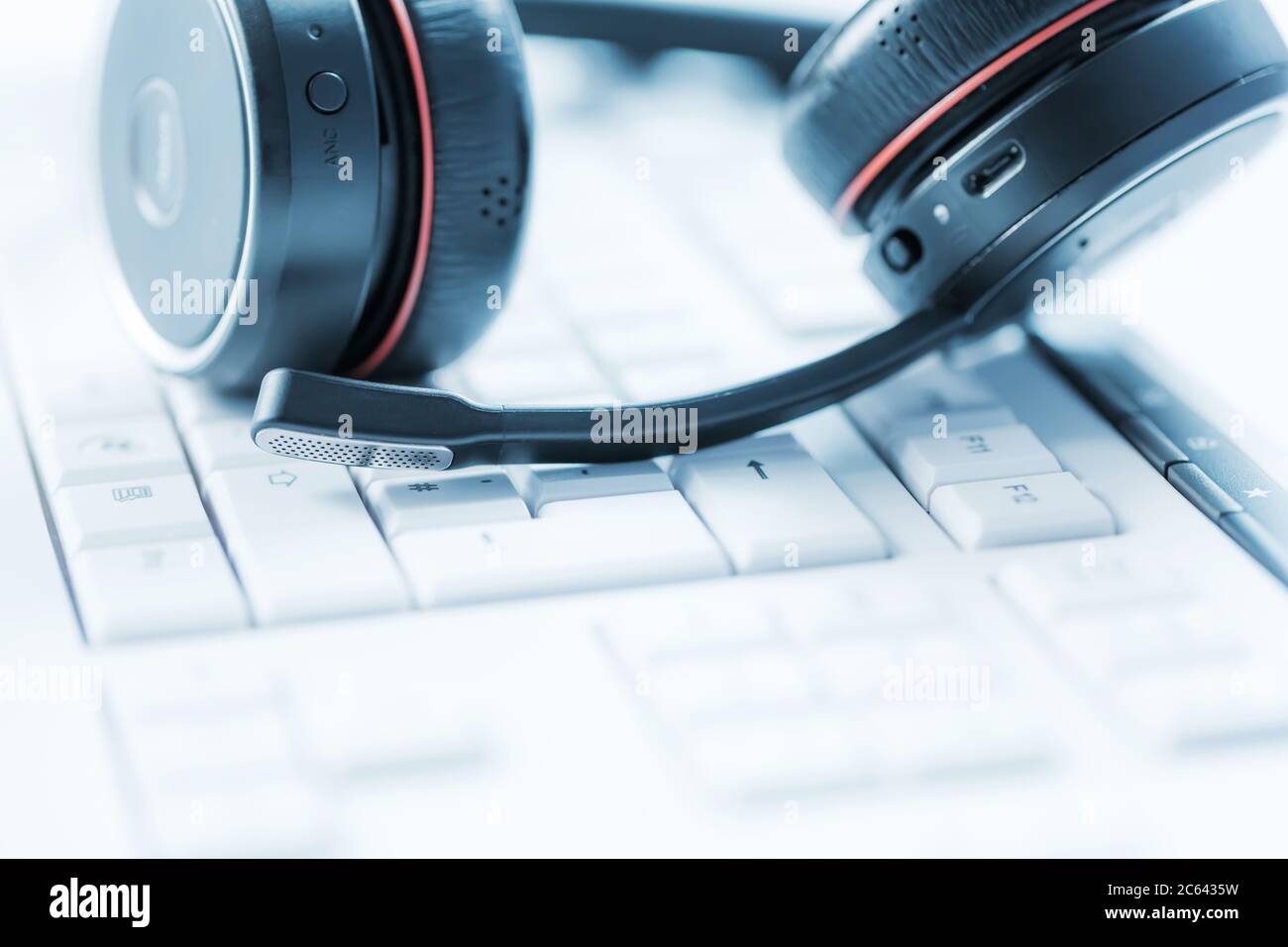 Concept of communication support, call center and customer service help desk. Headphones on keyboard. Soft focus. Stock Photo