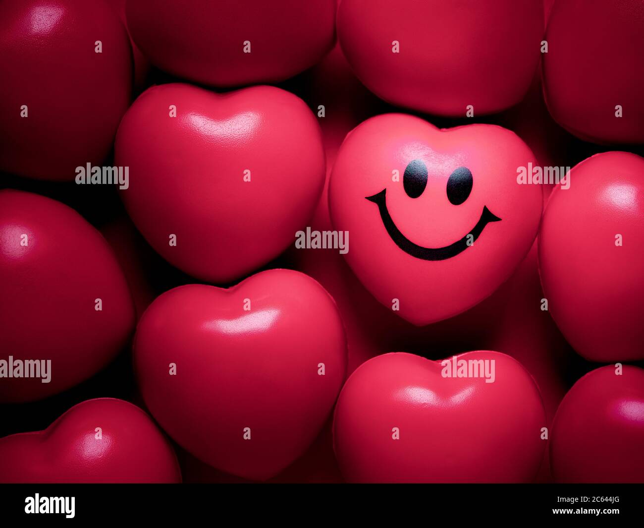 Hearts background. Pink heart with happy and smiling face among ...