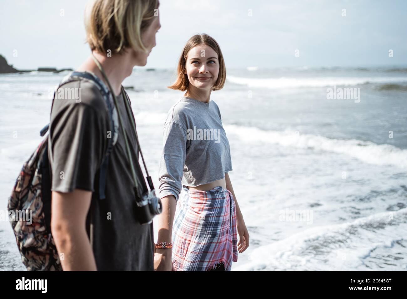 Young couple enjoy a trip together on the beach in the bright sunny day Stock Photo