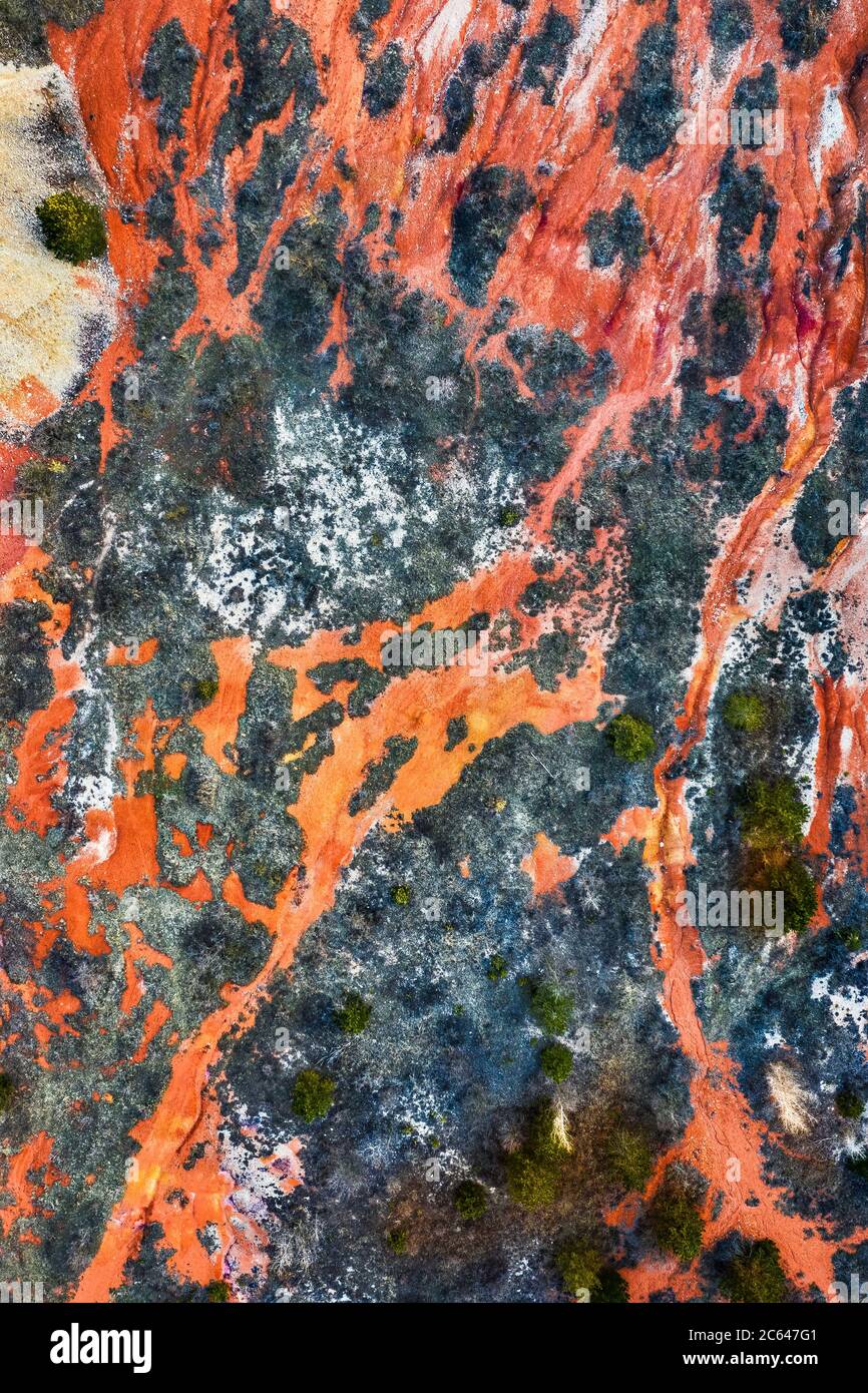 Gant, Hungary - Aerial horizontal drone view of abandoned bauxite mine with warm red and orange colors and trees at sunset. Red bauxite texture Stock Photo