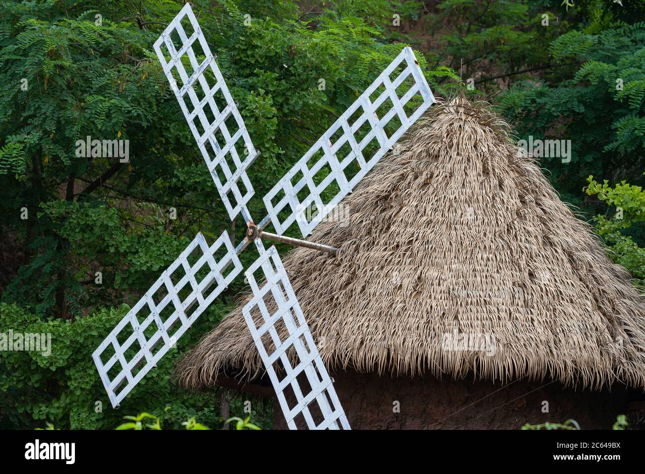 Outdoor turning barn windmill and green woods Stock Photo