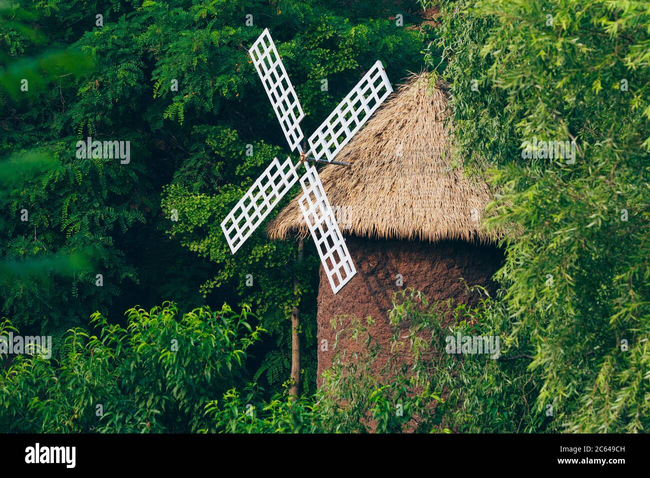 Outdoor turning barn windmill and green woods Stock Photo