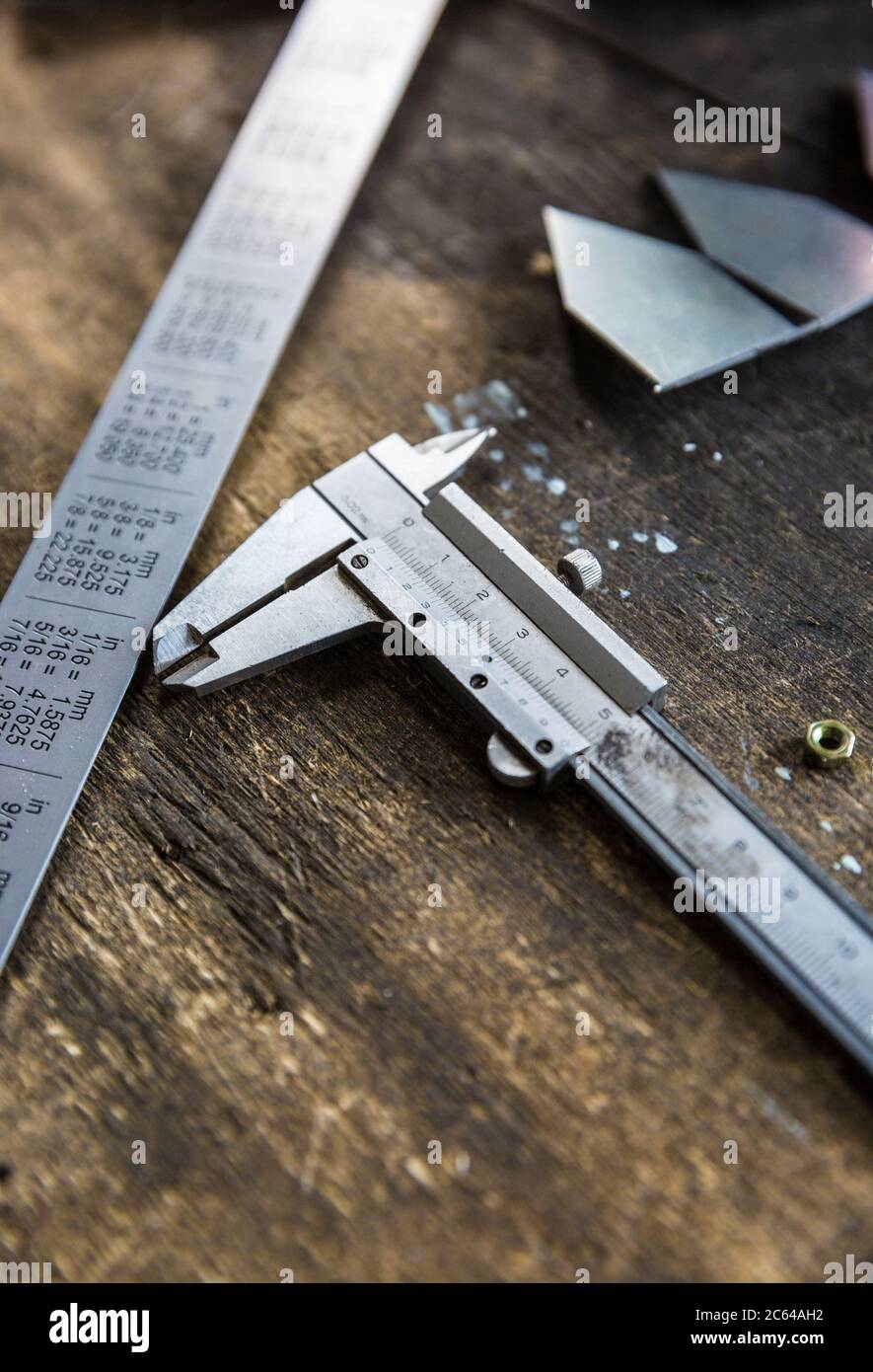 Vernier caliper and metal meter ruler on oil stained table, measuring tool Stock Photo