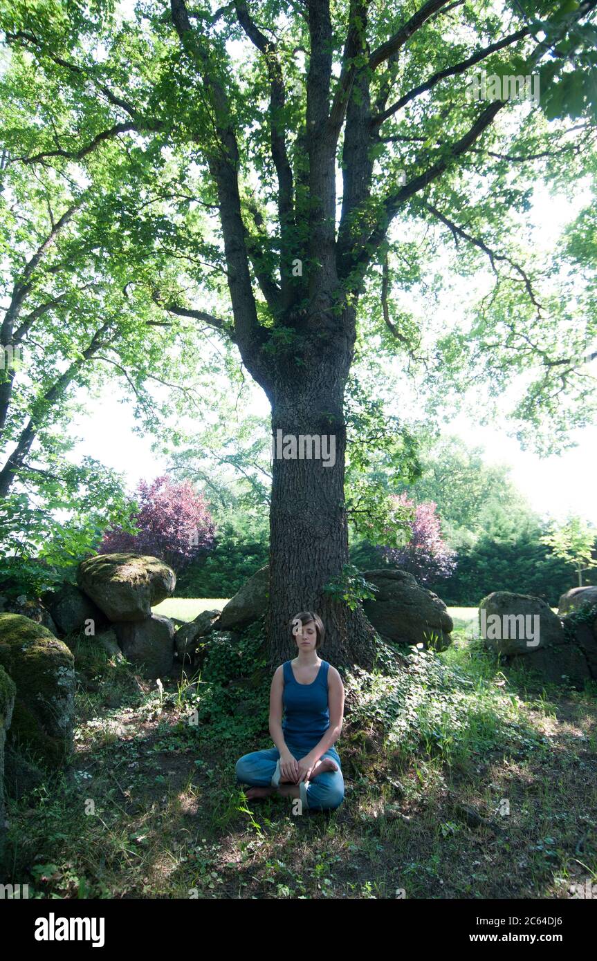 Meditating woman in the forest Stock Photo