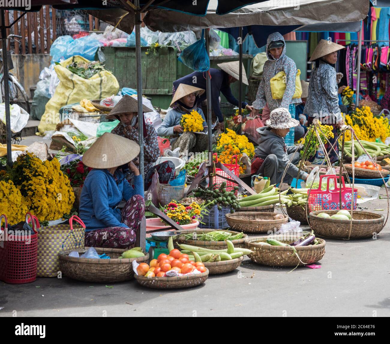 Vietnamese ladies selling fruit and vegetables  at a traditional Vietnamese street market in Hoi An  Vietnam Stock Photo