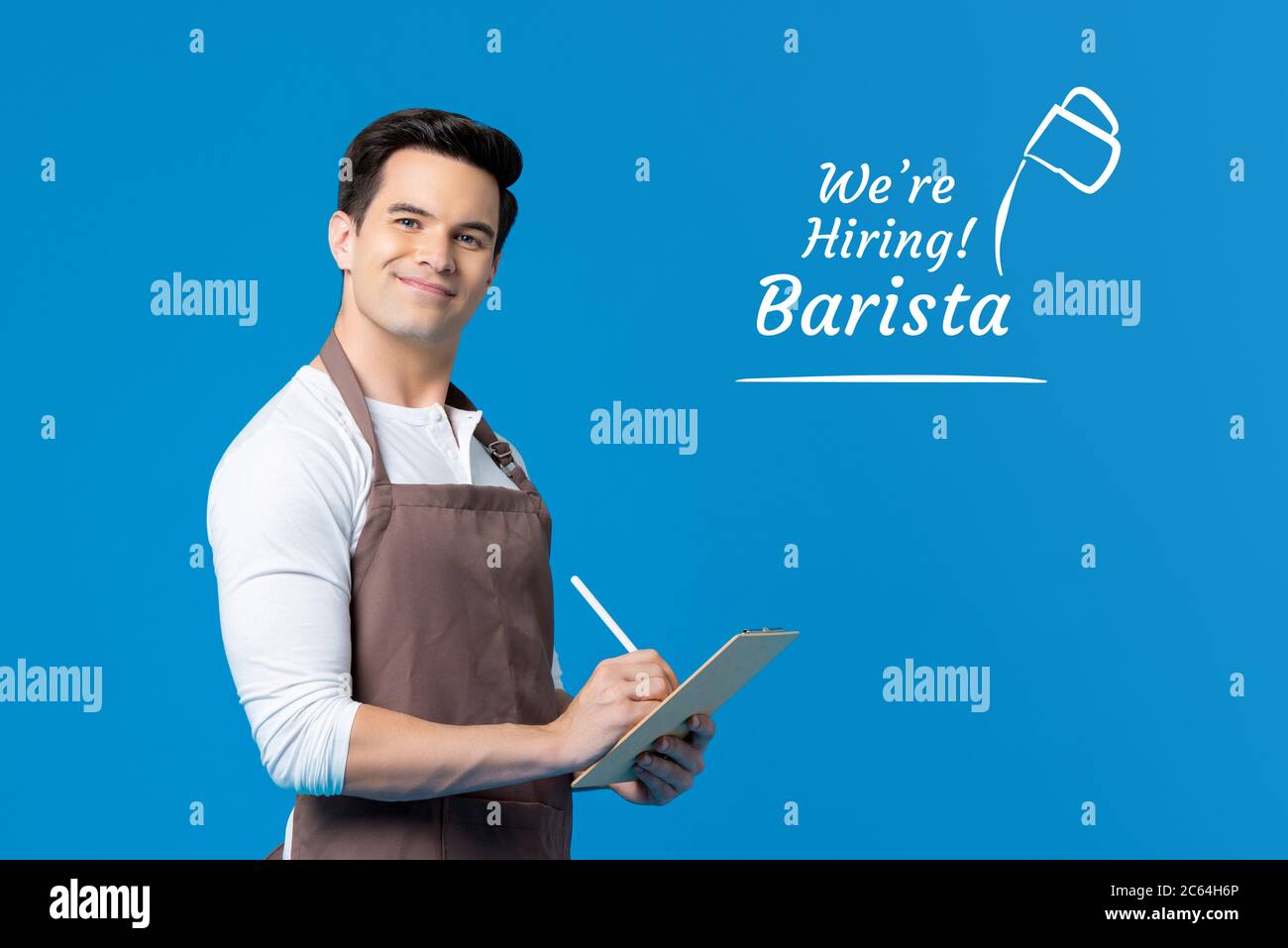 Portrait of smiling handsome Caucasian barista in writing gesture job hiring concept in isolated studio blue background Stock Photo