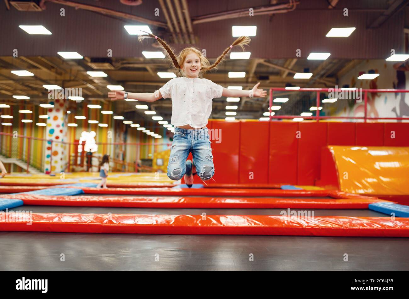 Girl jumping on trampoline in entertainment center Stock Photo - Alamy