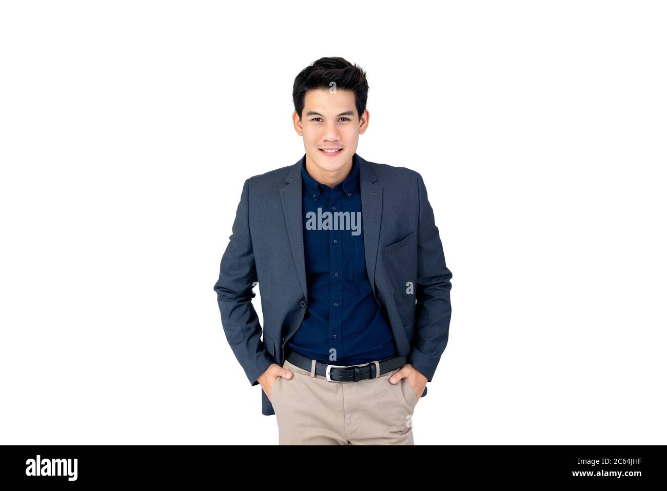 Portrait of confident smiling Asian businessman looking at camera with both hands in his pockets in isolated studio white background Stock Photo