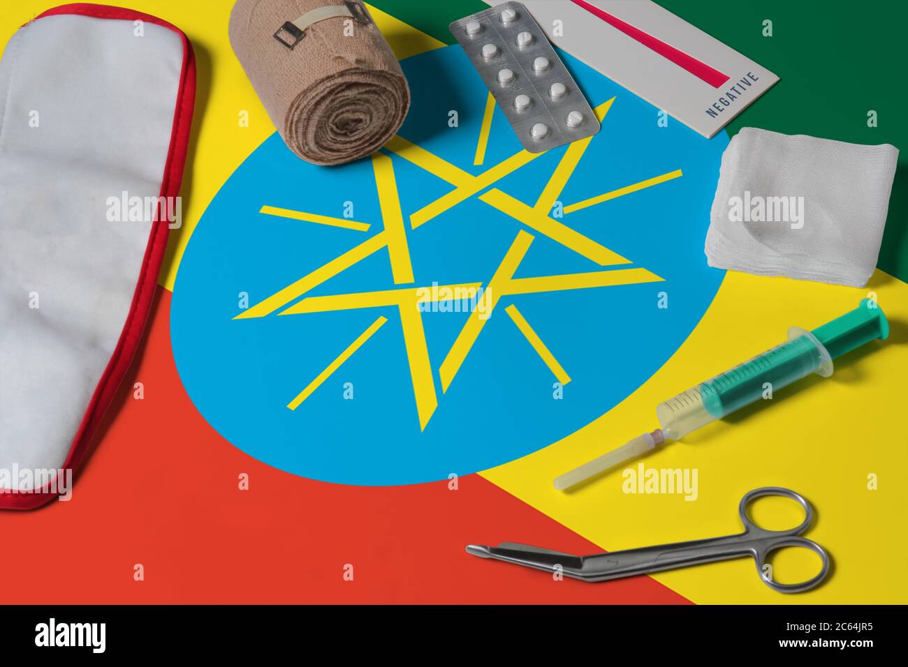 Ethiopia flag with first aid medical kit on wooden table background