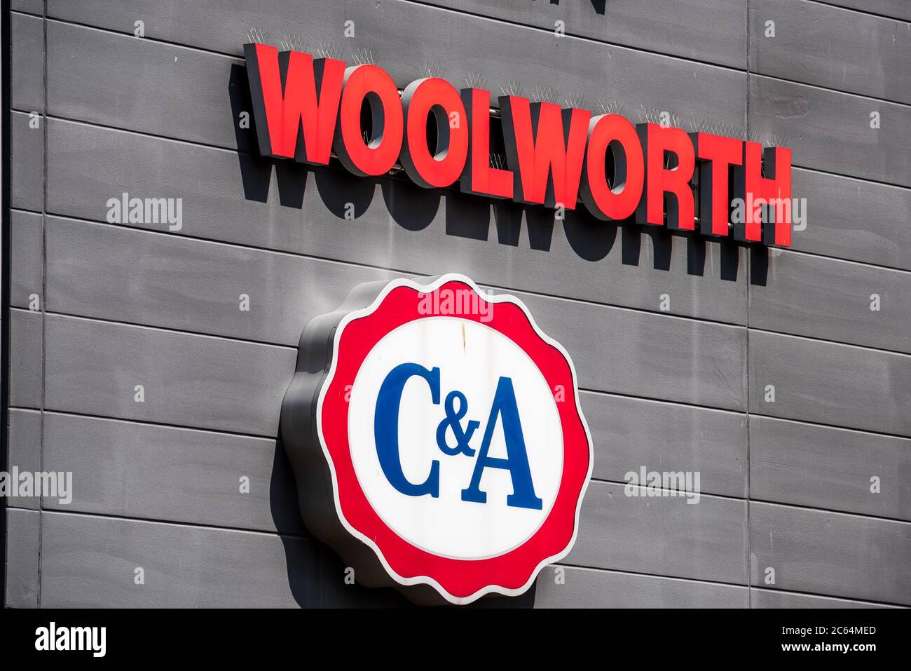 Woolworth und Werbebanner verschiedener Firmen an der Fassade eines Geschäfthauses Stock Photo
