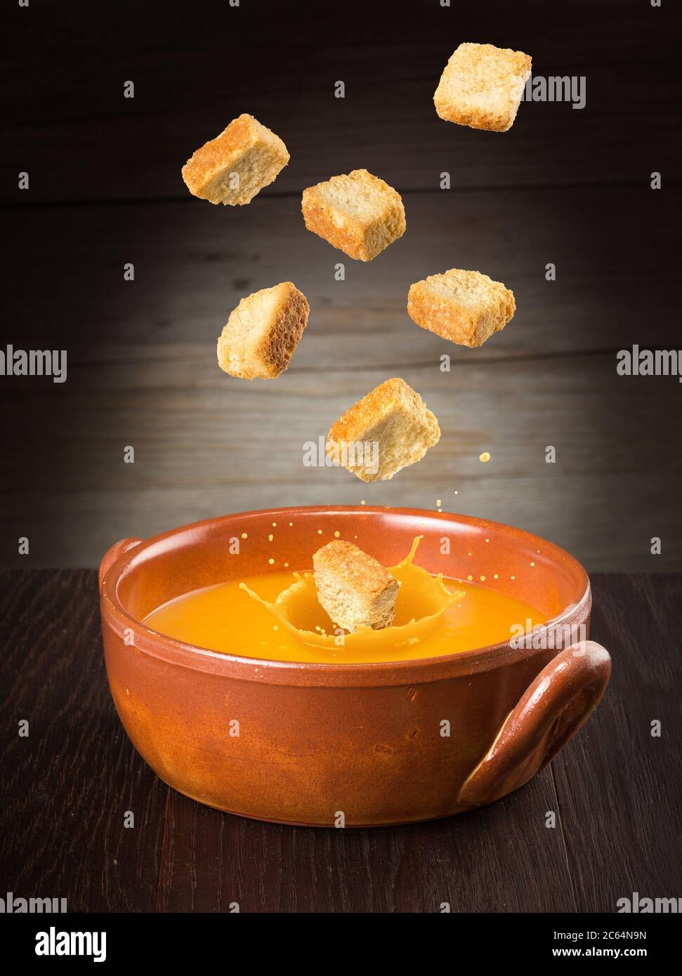 croutons falling into a splashing pumpkin soup Stock Photo - Alamy