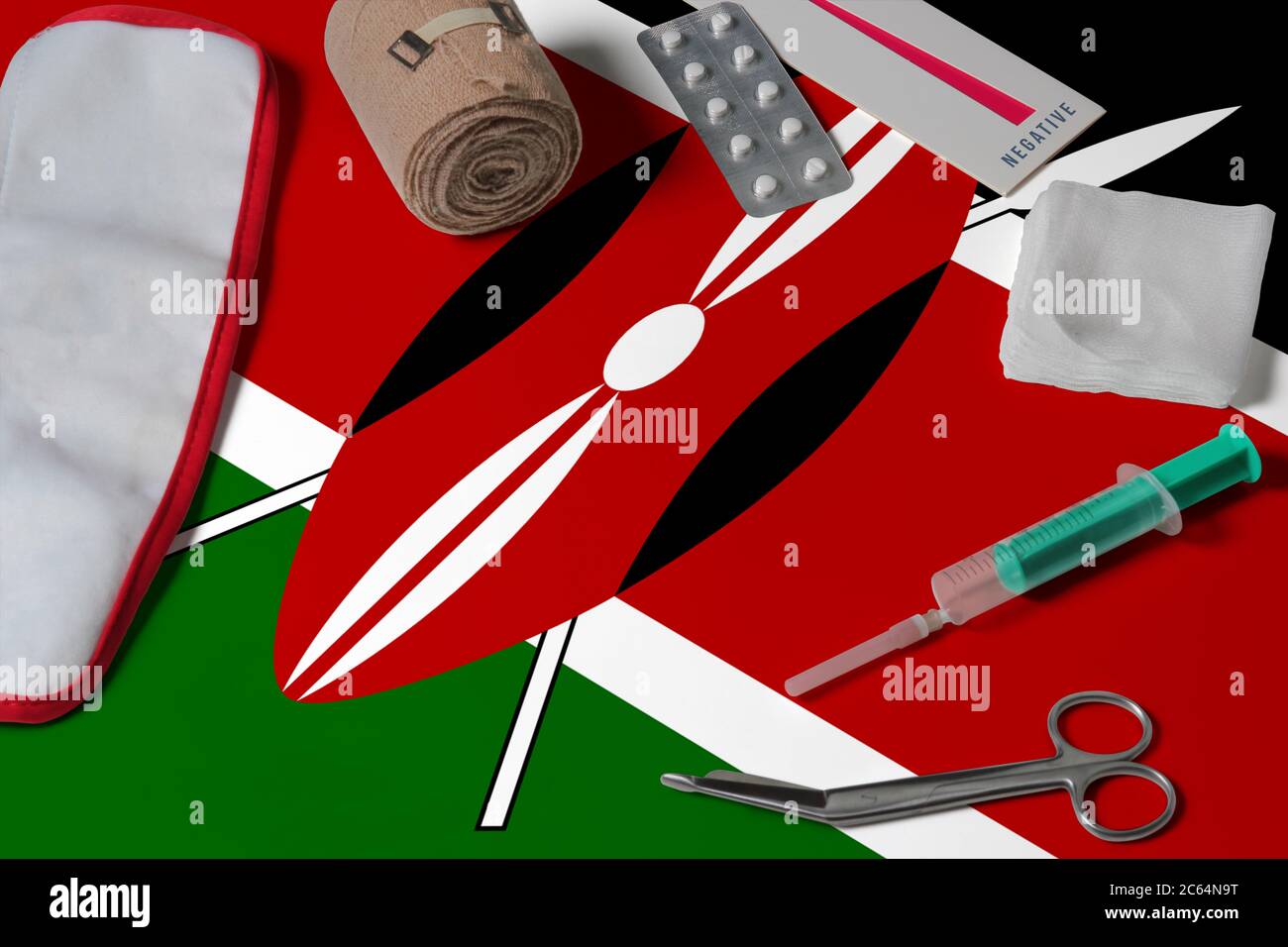 Kenya flag with first aid medical kit on wooden table background