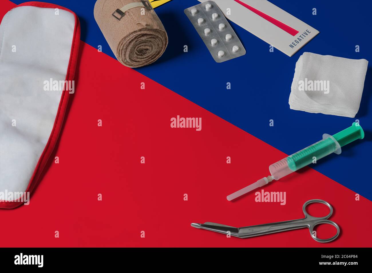 Liechtenstein flag with first aid medical kit on wooden table background. National healthcare system concept, medical theme. Stock Photo