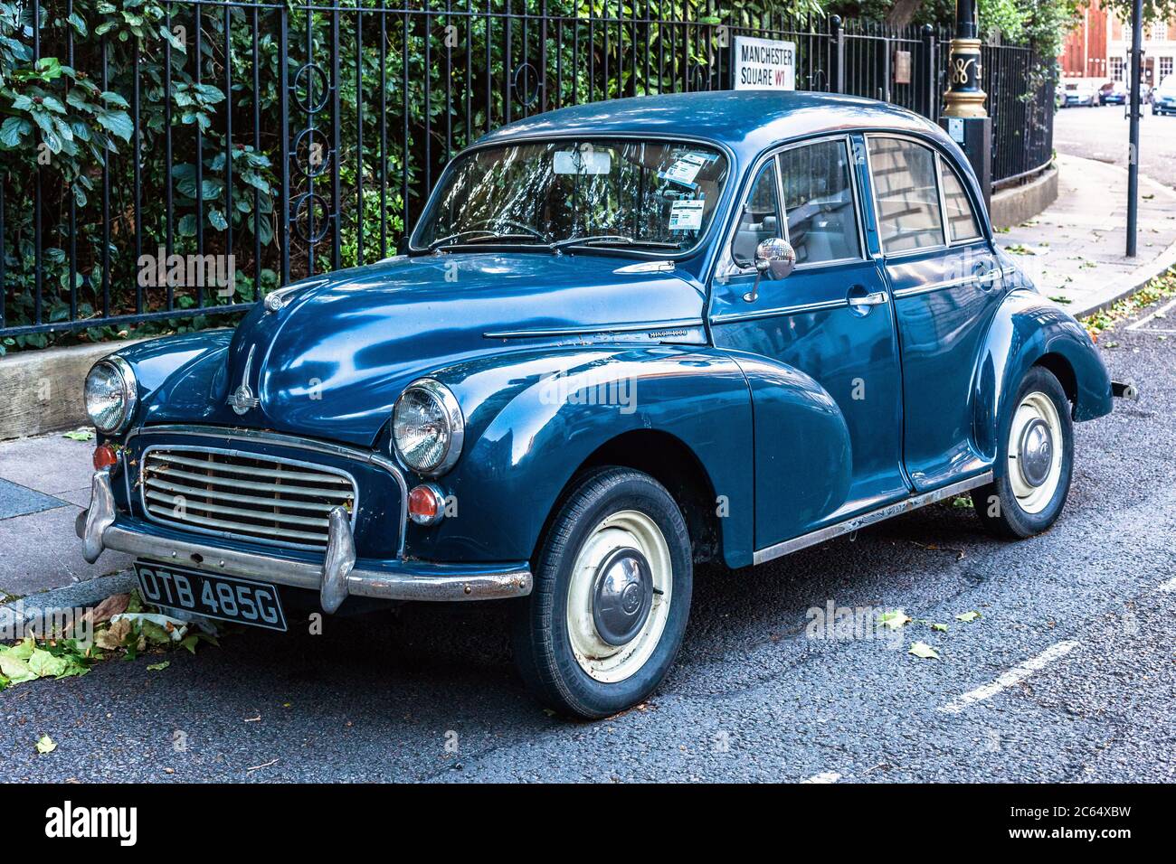 Three quarter front view of a blue Morris Minor 1000 car, parked on one side of a road, London, England, UK. Stock Photo