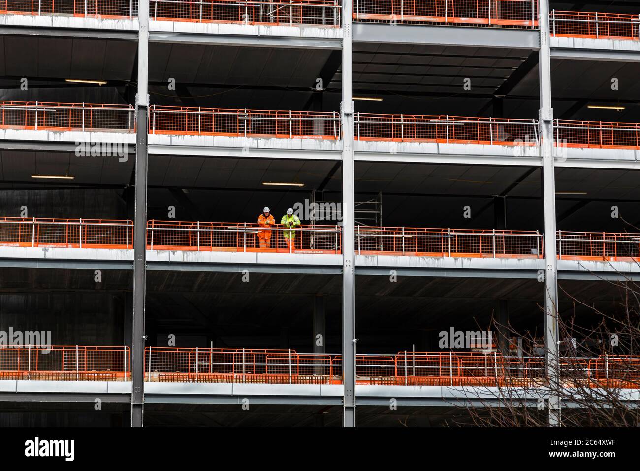 Construction site UK, two workers standing at the edge of a multi storey building, Glasgow, Scotland, UK Stock Photo