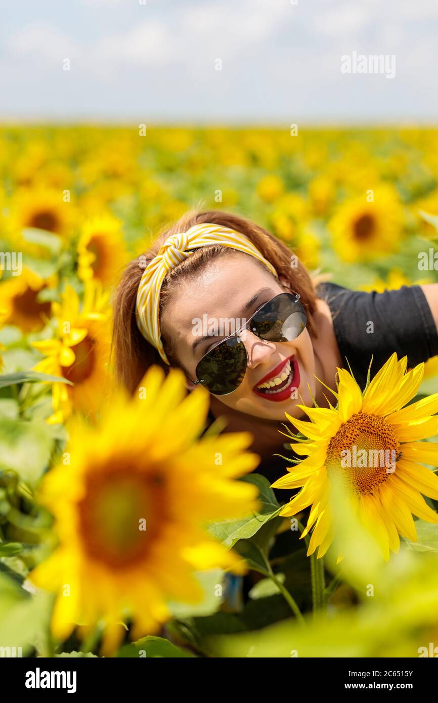 Pretty young woman on a sunflowers field Stock Photo - Alamy