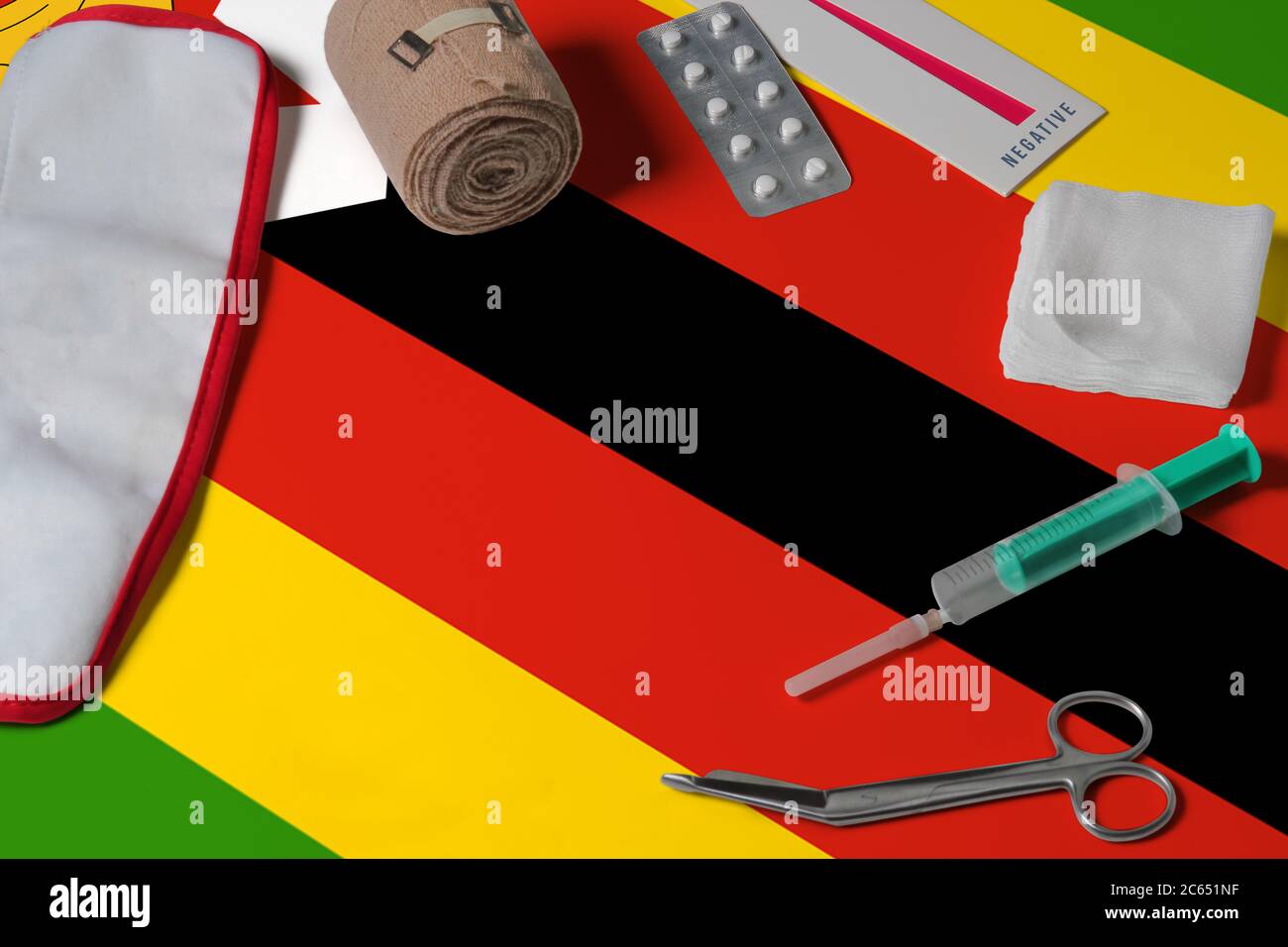 Zimbabwe flag with first aid medical kit on wooden table background