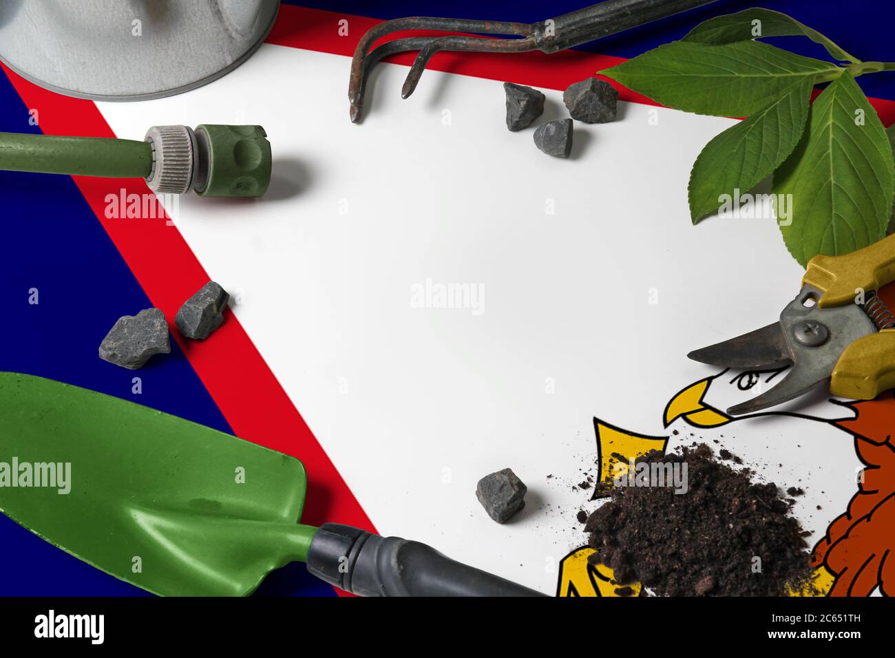 American Samoa flag with gardening tools background on table. Spring in the garden concept with free copy space. Stock Photo