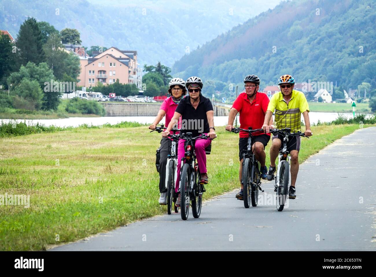 Seniors cycling on a bike path Germany People biking along the Elbe river, vacation Stock Photo