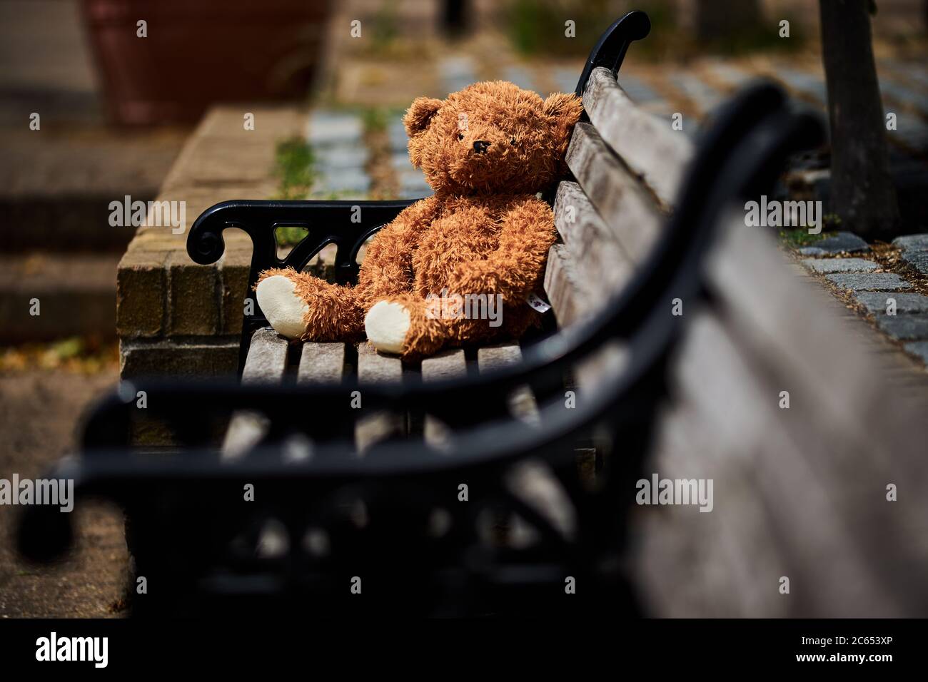 A abandoned or lost teddy bear left on a bench in old Isleworth, London ...