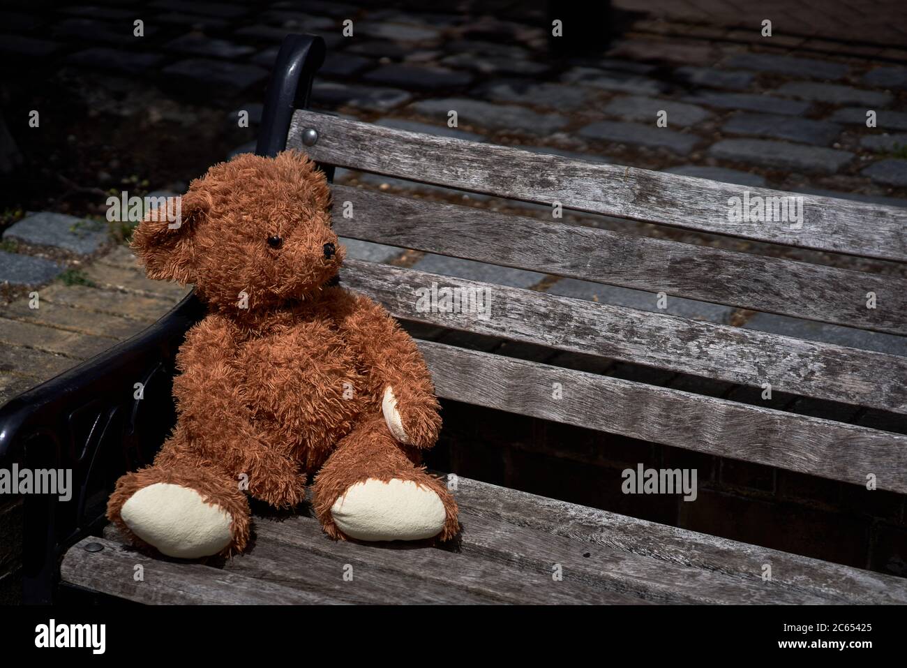 A abandoned or lost teddy bear left on a bench in old Isleworth, London ...