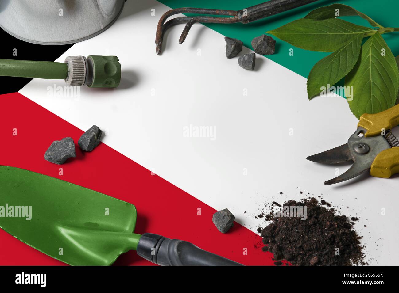 Kuwait flag with gardening tools background on table. Spring in the