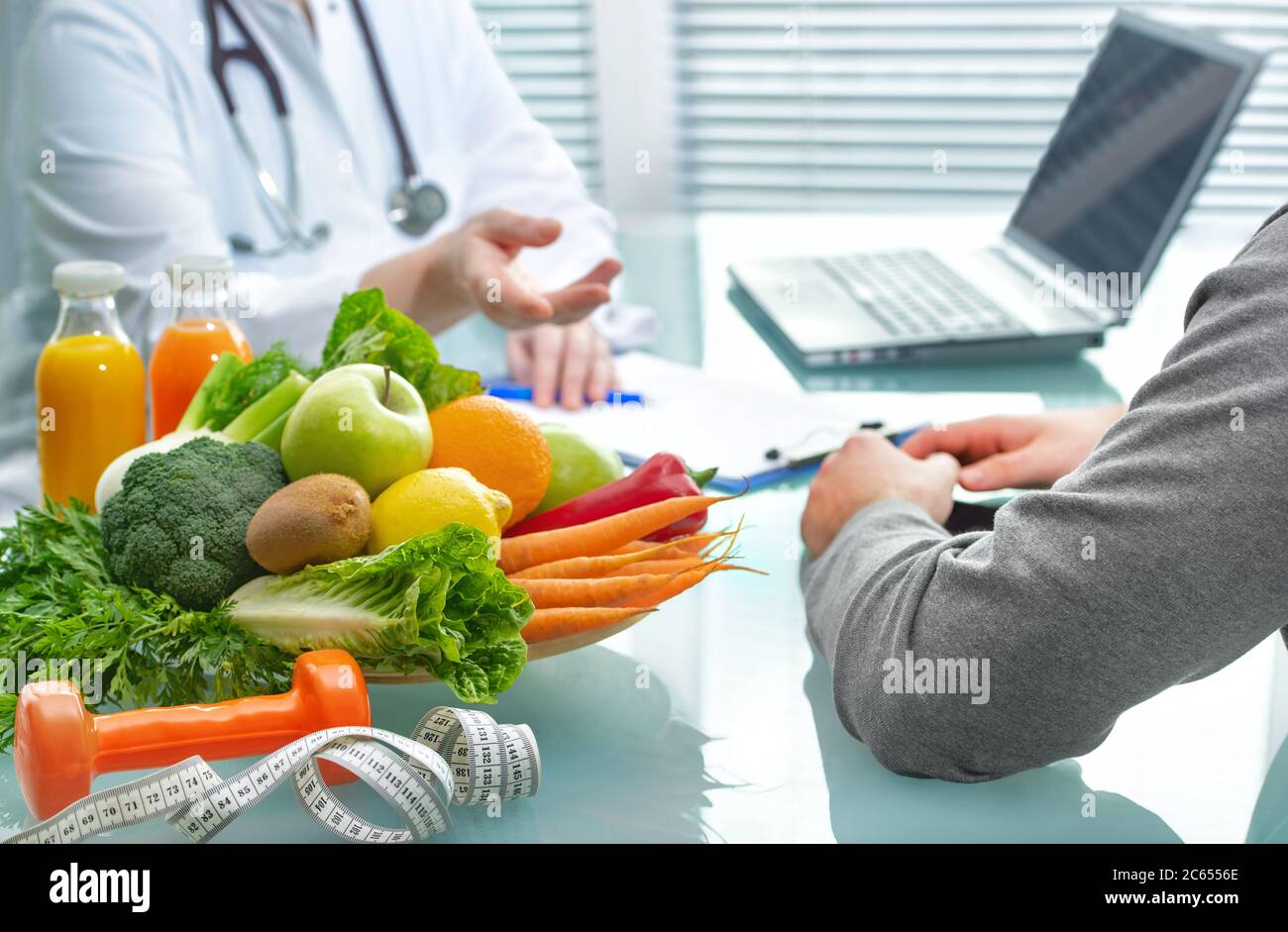 Nutritionist is consulting the patient about healthy diet with vegetables and fruits. Nutrition und dieting concept Stock Photo
