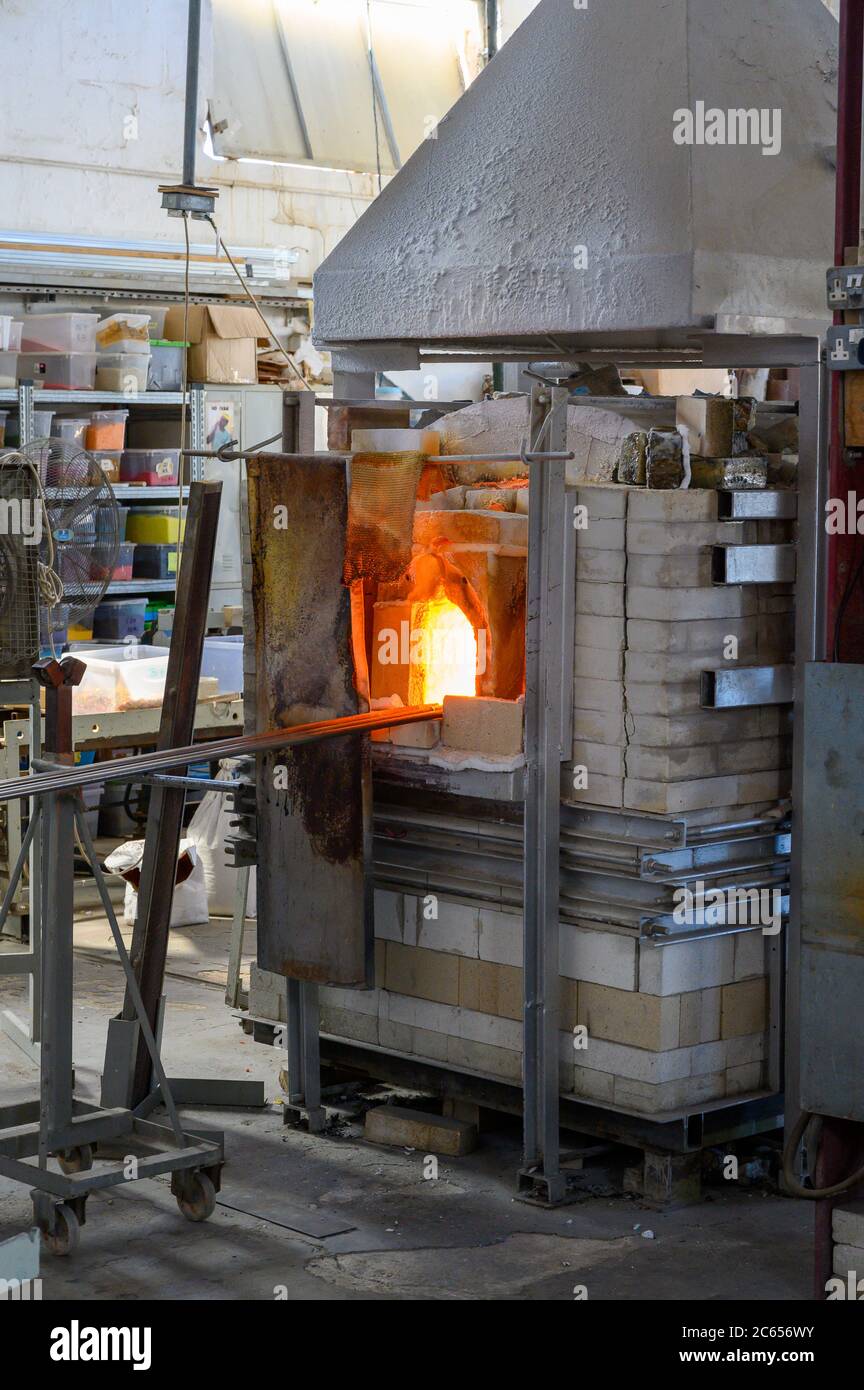 Glass Blowers Oven with the rods inside. The door is open showing the hot glow. Stock Photo