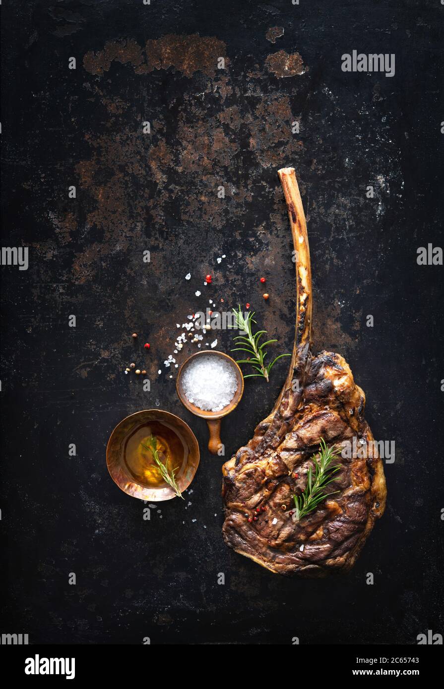 Grilled tomahawk beef steak with spices on dark rustic background Stock Photo