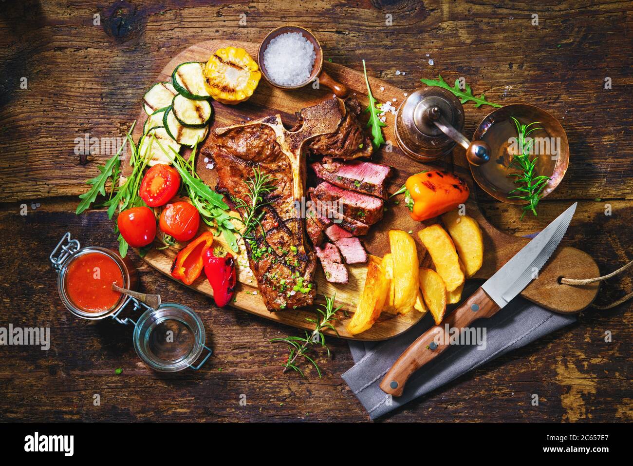 Beef steak with grilled vegetables and seasoning on serving board Stock