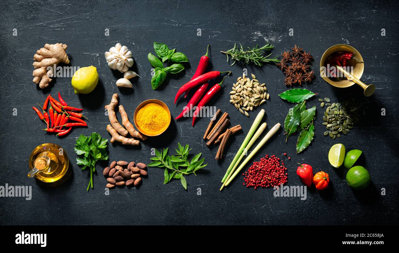 Colourful various herbs and spices for cooking on dark background Stock Photo