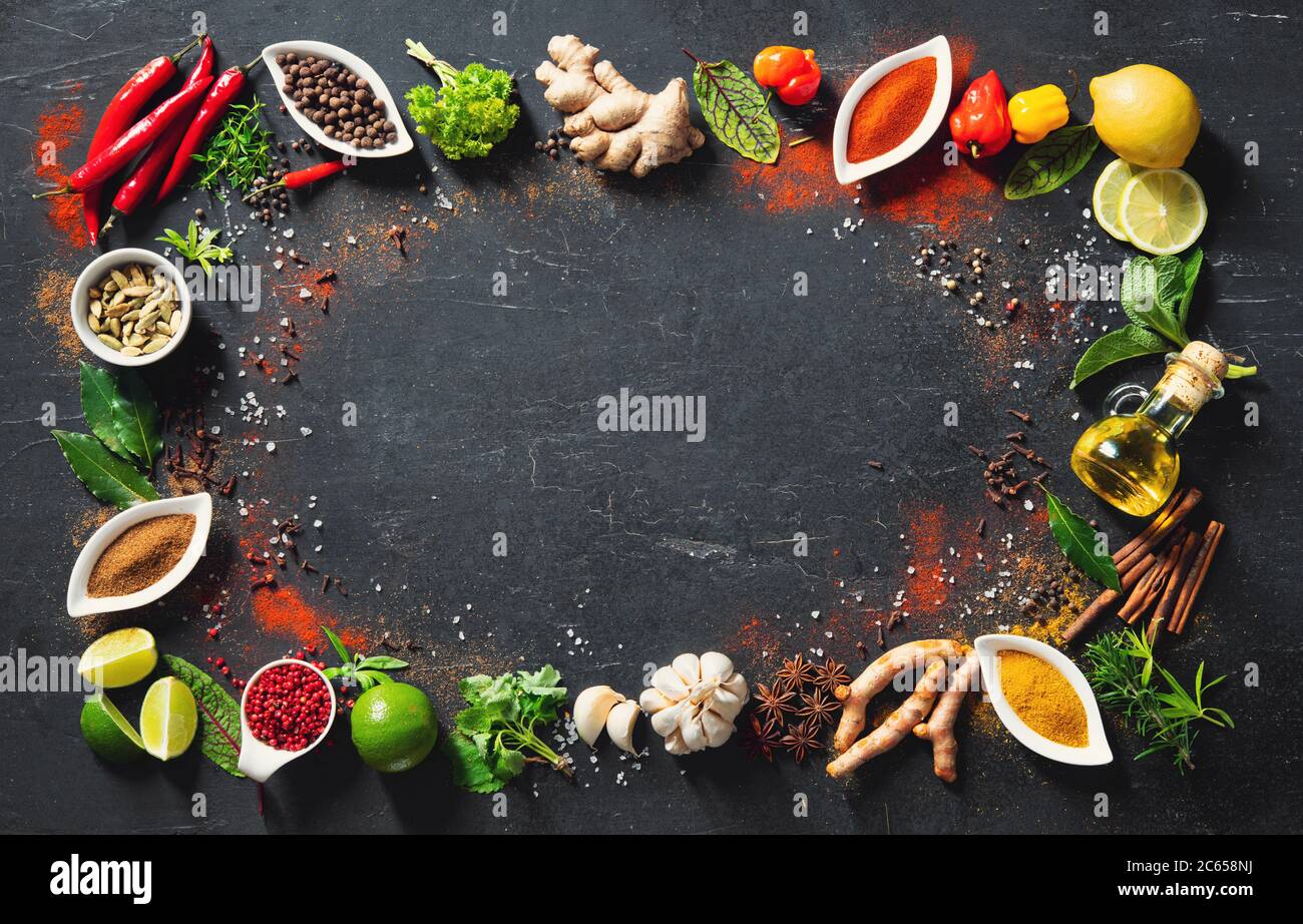 Colourful background of various herbs and spices in bowls for cooking with copy space for your text Stock Photo