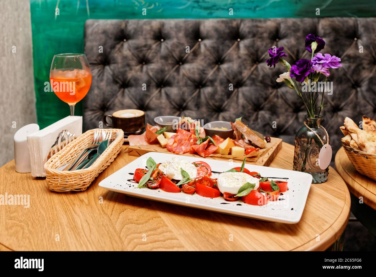 Caprese salad and set of appetizers on restaurant table, toned Stock Photo