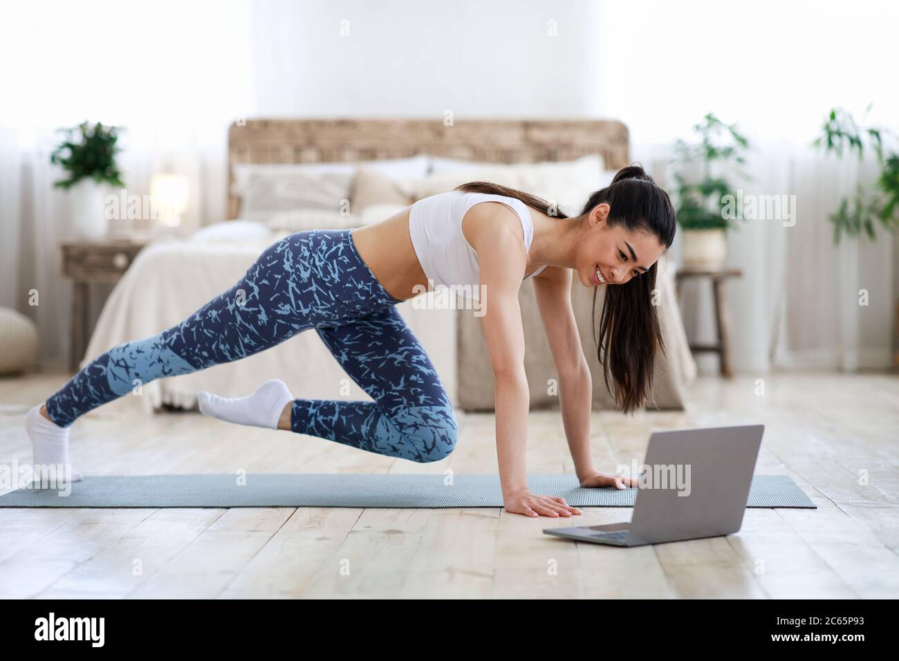 Home Workout. Young Asian Girl Practicing Sport In Front Of Laptop Stock Photo