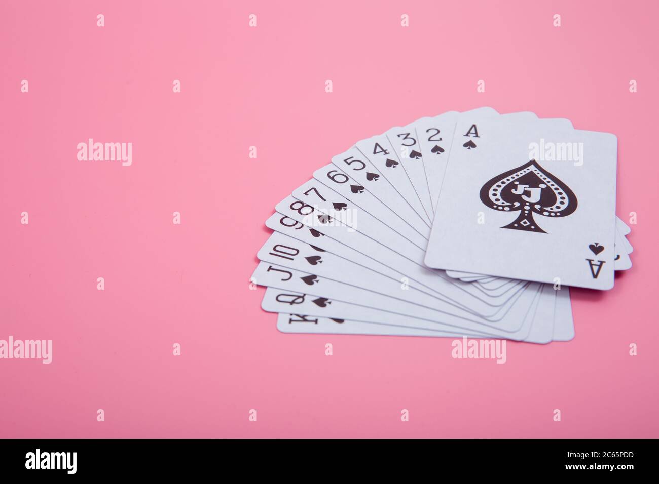 Expanded playing cards on pink background Stock Photo