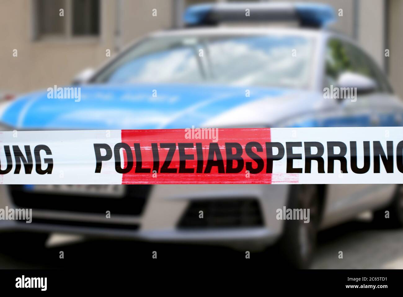 Symbolbild: Polizeiabsperrung mit Polizeiauto im Hintergrund Stock Photo