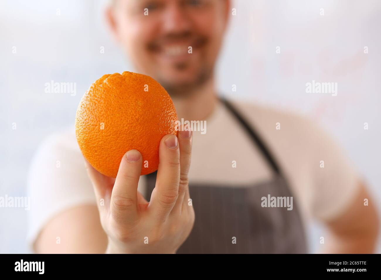 Man holding fresh orange fruit hi-res stock photography and images - Alamy