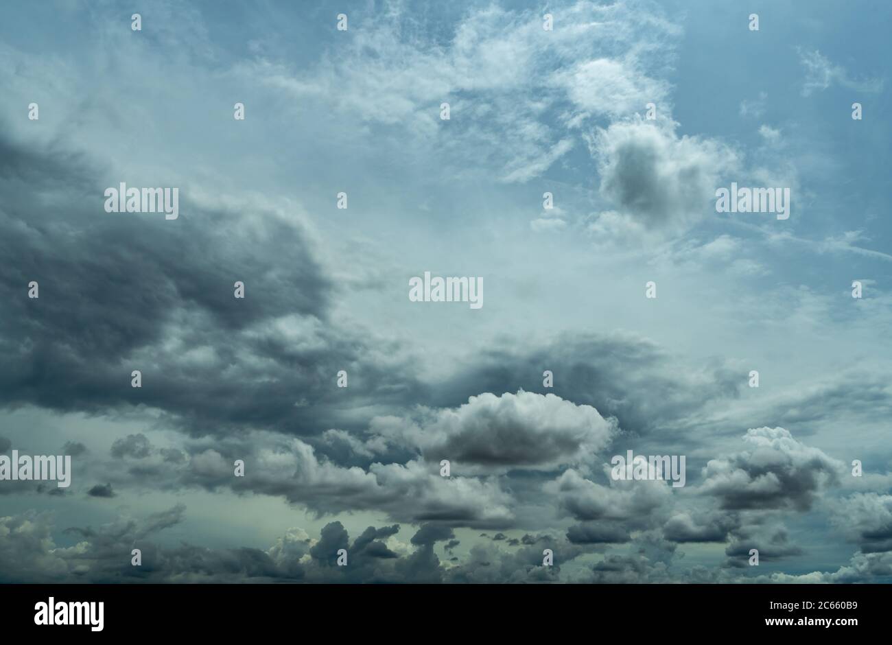 Blue sky and dark cumulus clouds. Cloudscape. Blue sky and fluffy clouds. The storm sky before raining. Rain clouds. Beauty in nature. Nature Stock Photo