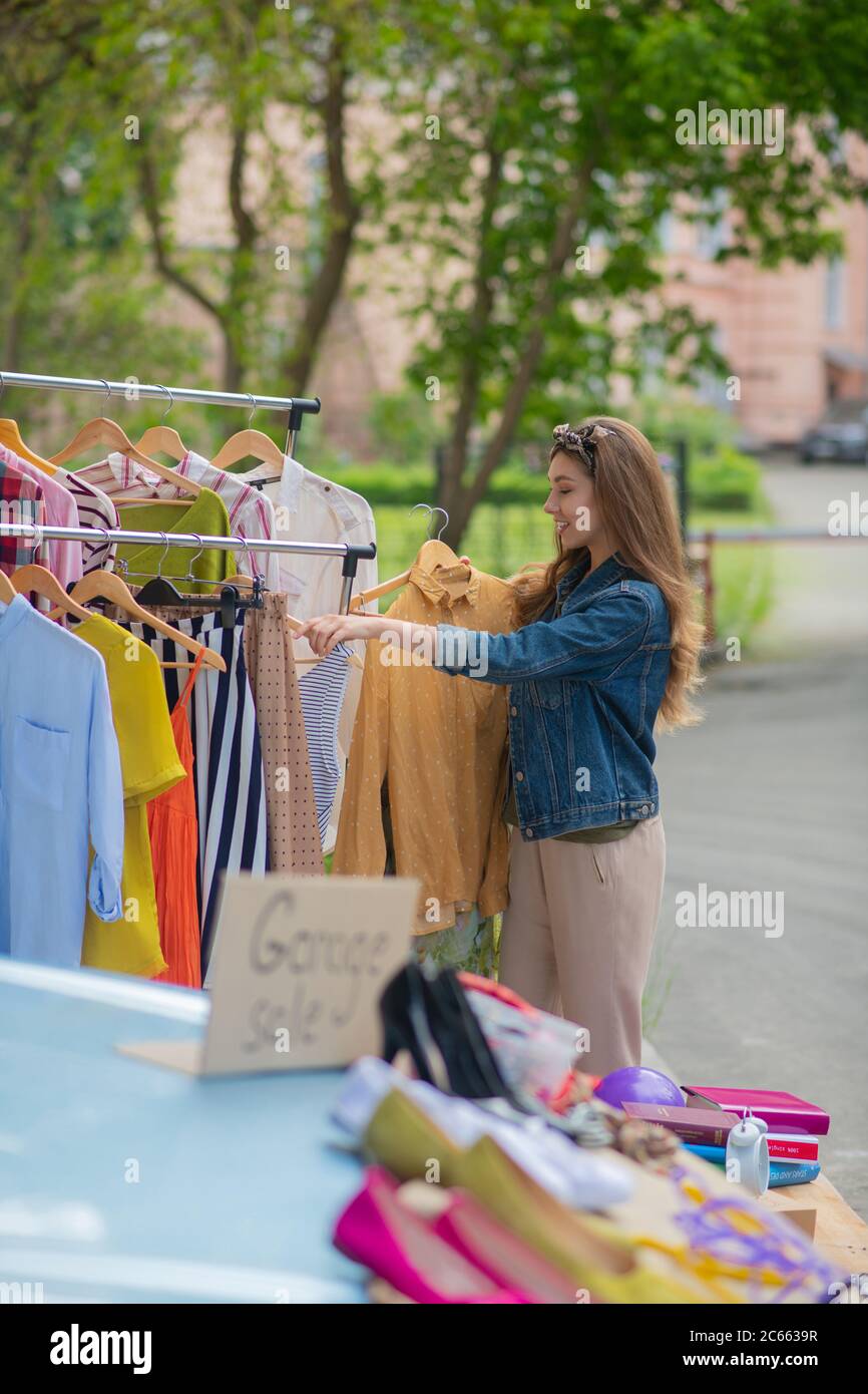 Nice pretty woman looking through different clothes Stock Photo