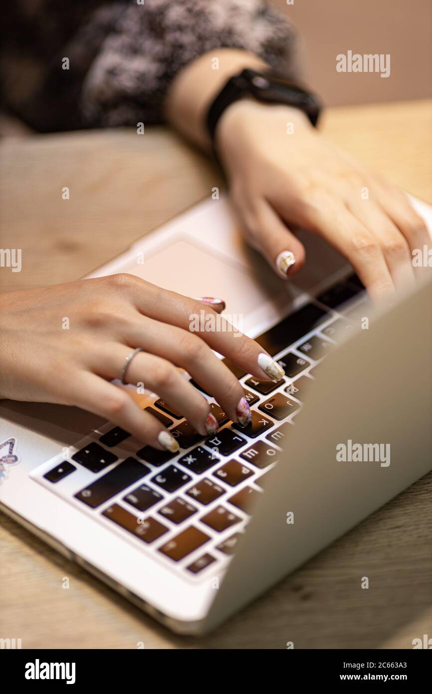 womens hands typing on a laptop computer, cropped view Stock Photo
