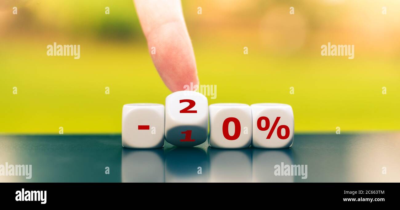 Hand turns dice and changes the expression "-10%" to "-20%". Stock Photo