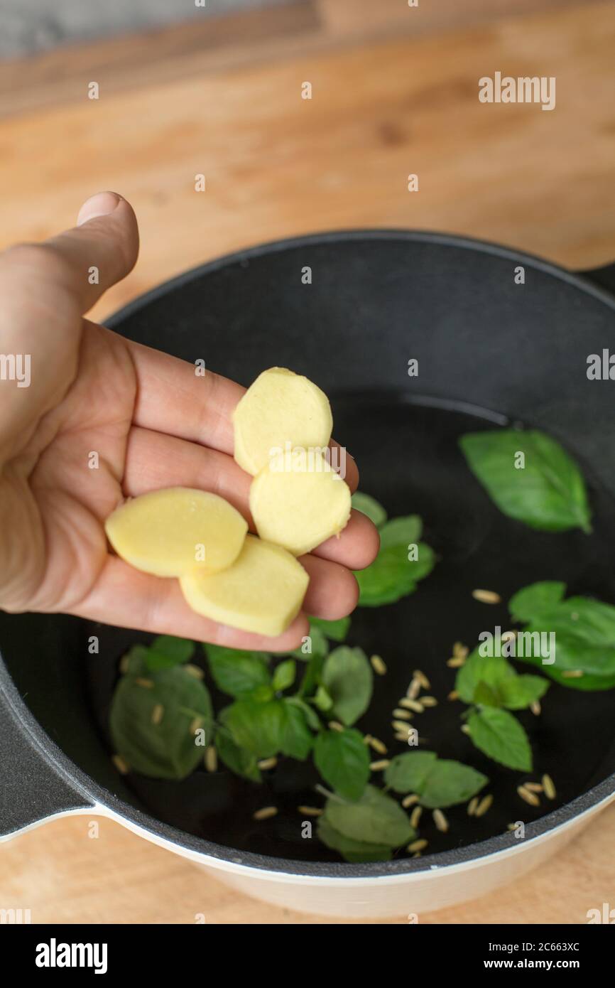 Make your own Ayurveda drink: Add the ingredients to the water that is no longer boiling and put the lid on the pot. Stock Photo