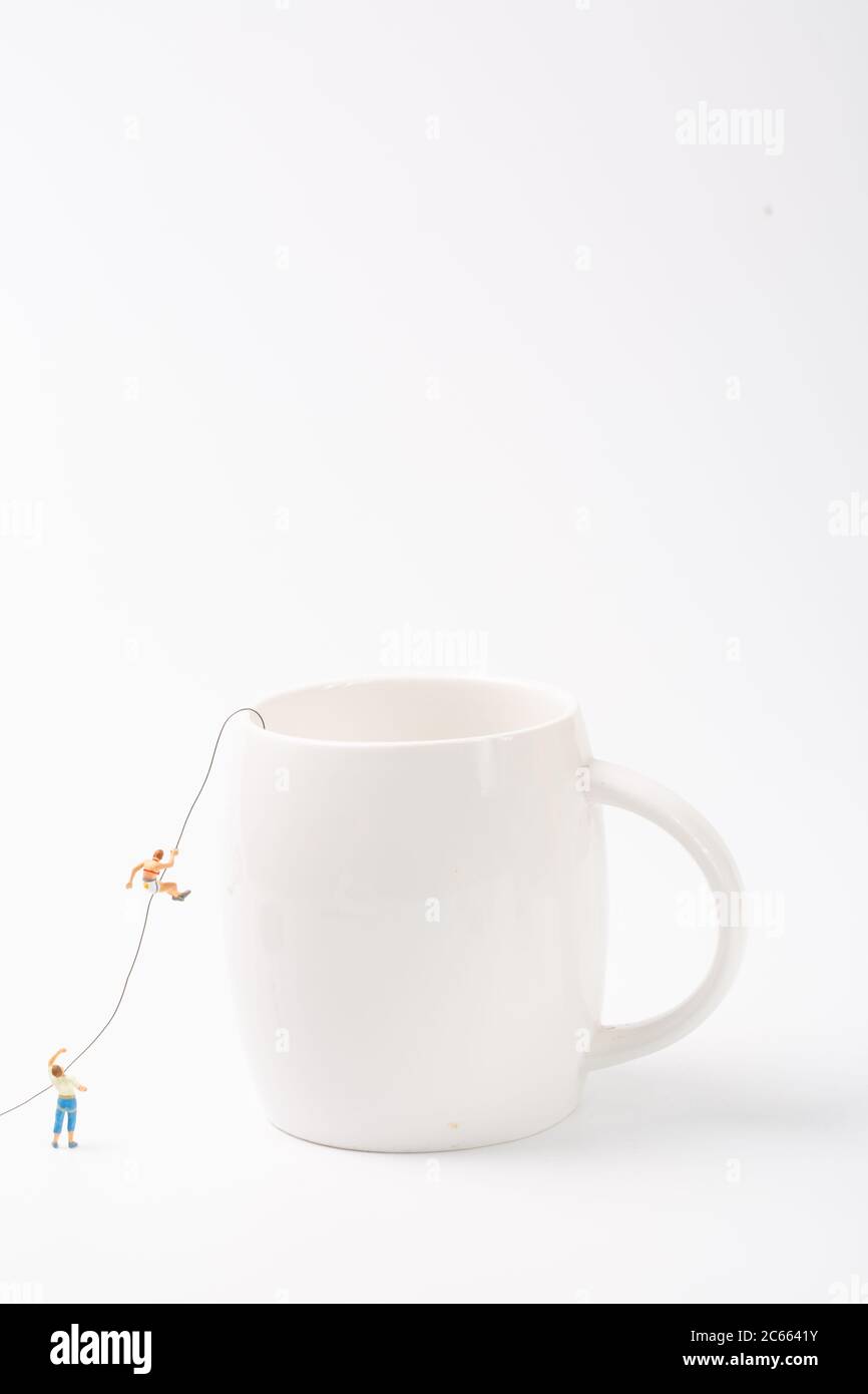 Man climbing cup on white background Stock Photo