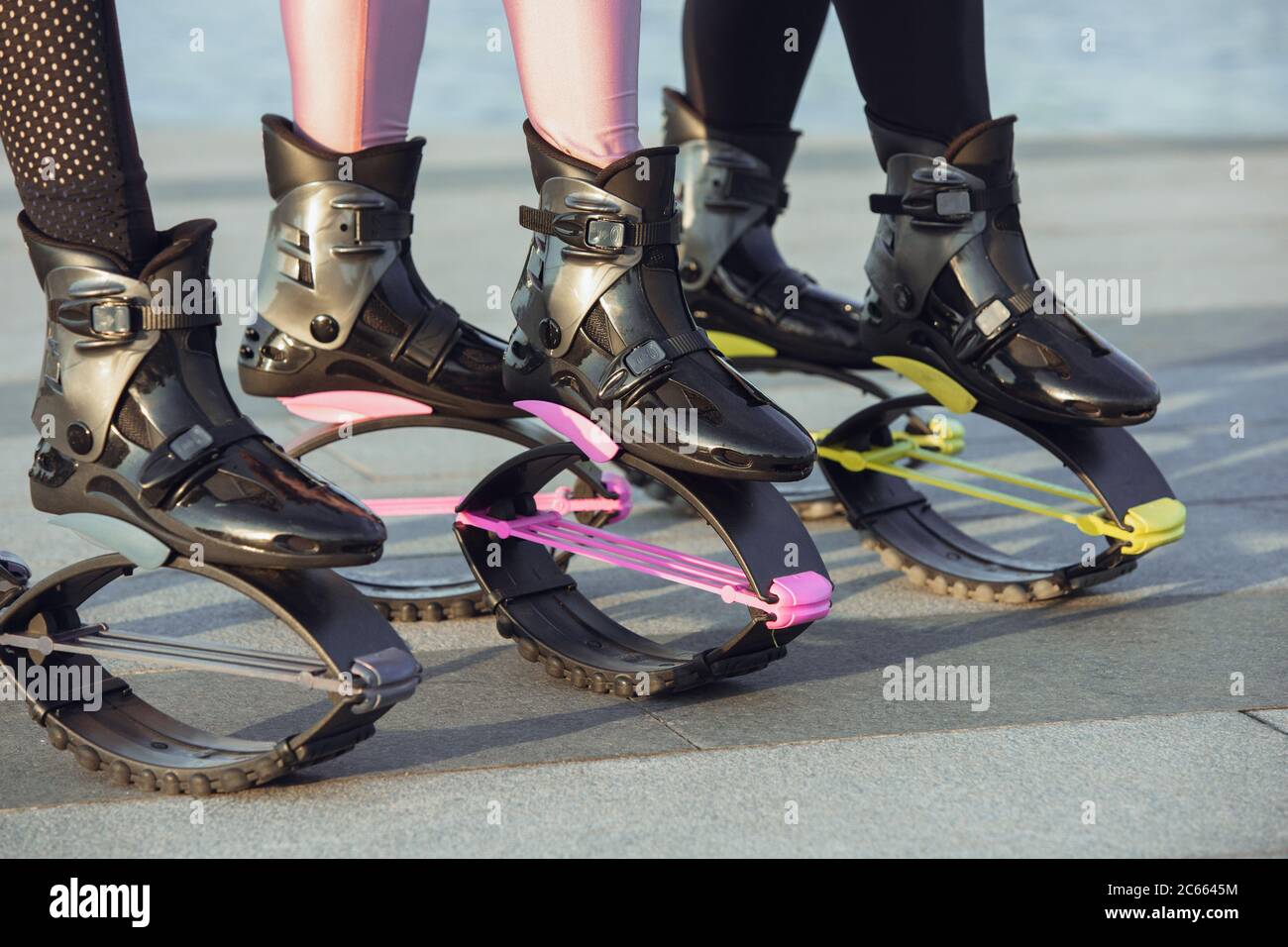 Two Women Put on Kangoo Jumping Boots and Smiles. Beautiful Girls Wearing  Shoes before Outdoor Fitness Workout Stock Photo - Image of footwear,  group: 143325054