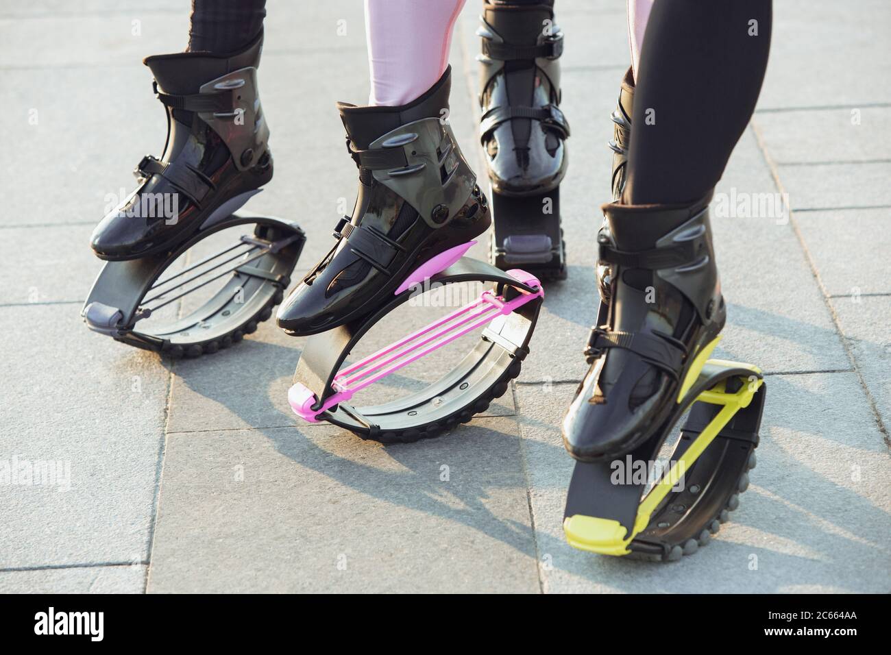 Two Women Put on Kangoo Jumping Boots and Smiles. Beautiful Girls Wearing  Shoes before Outdoor Fitness Workout Stock Photo - Image of footwear,  group: 143325054