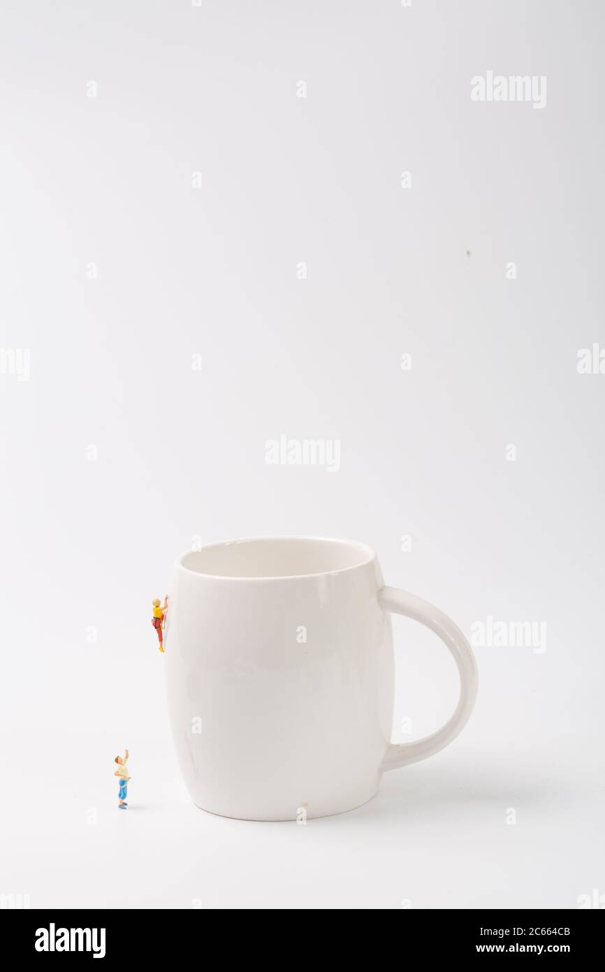 Man climbing cup on white background Stock Photo