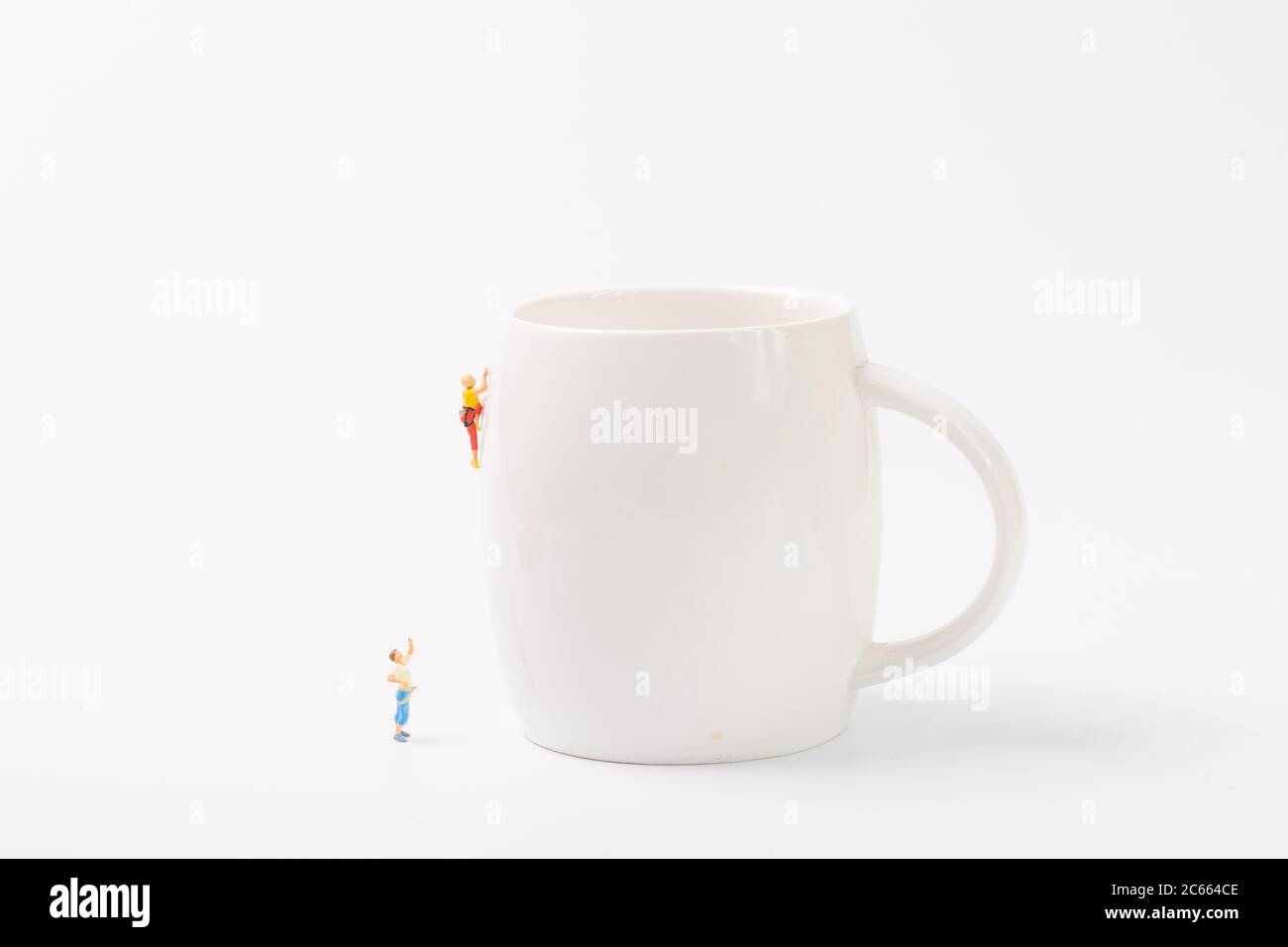 Man climbing cup on white background Stock Photo